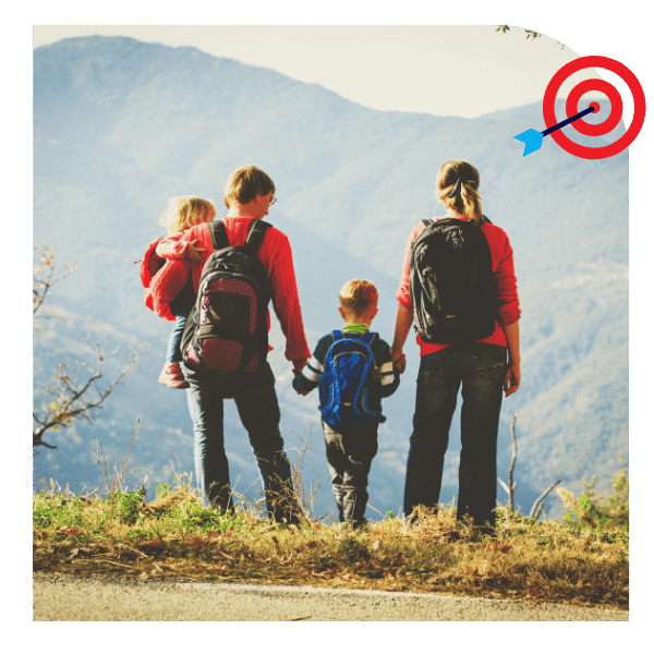 Famille avec des sacs à dos profitant d'une randonnée en montagne, regardant l'horizon avec des enfants.