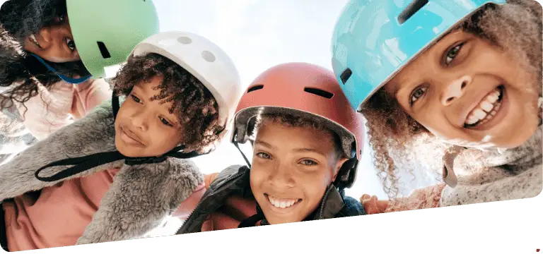 Quatre enfants souriants portant des casques, participant à des activités d'apprentissage en plein air avec Magikenglish